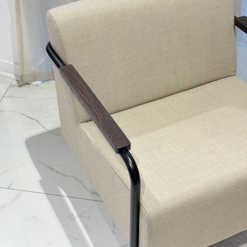 Assise rembourrée en tissu beige et accoudoir en bois foncé du fauteuil Mommo