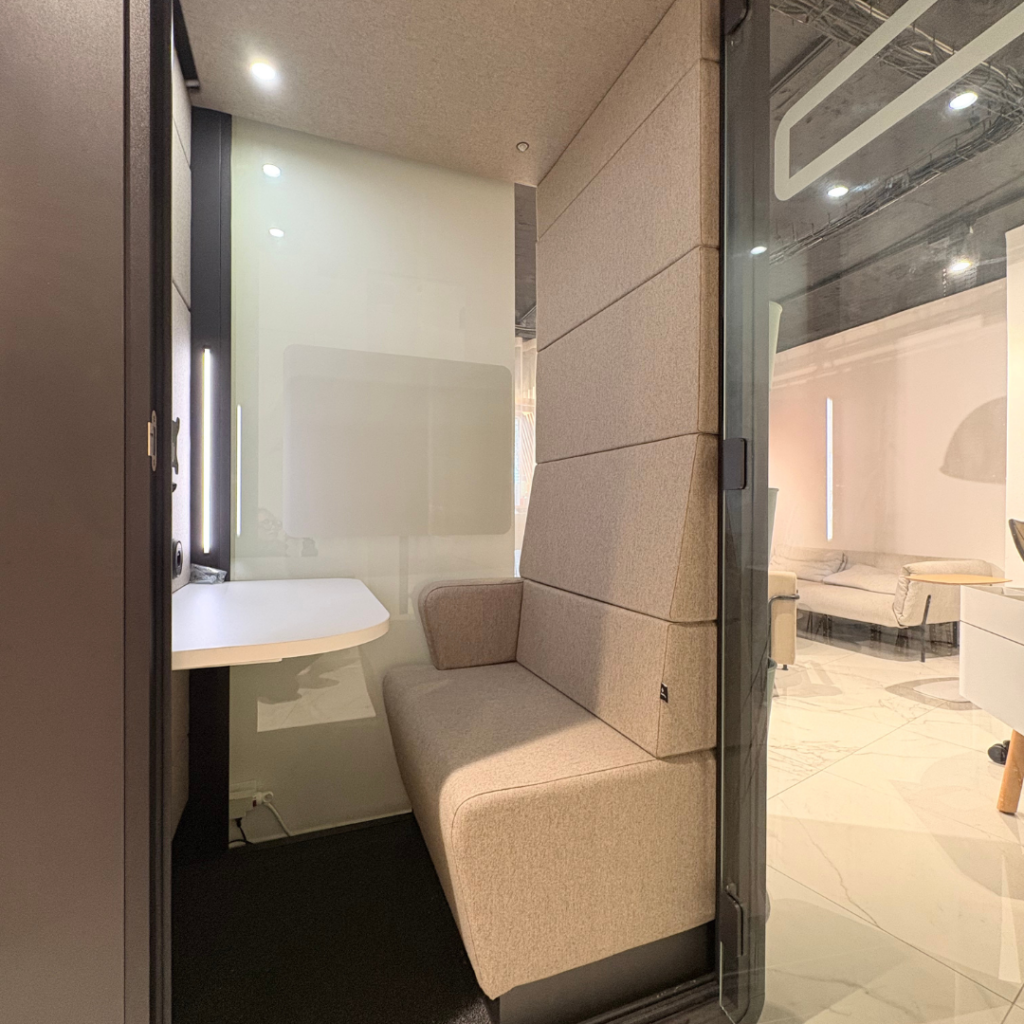 Intérieur de la cabine hushHybrid avec banquette rembourrée et panneaux acoustiques en feutre gris